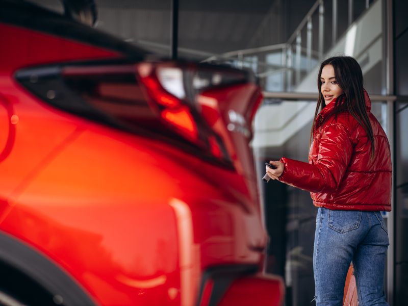 woman-standing-by-her-new-red-car-min-(1).jpg