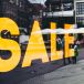 a big yellow sign sale on a store window