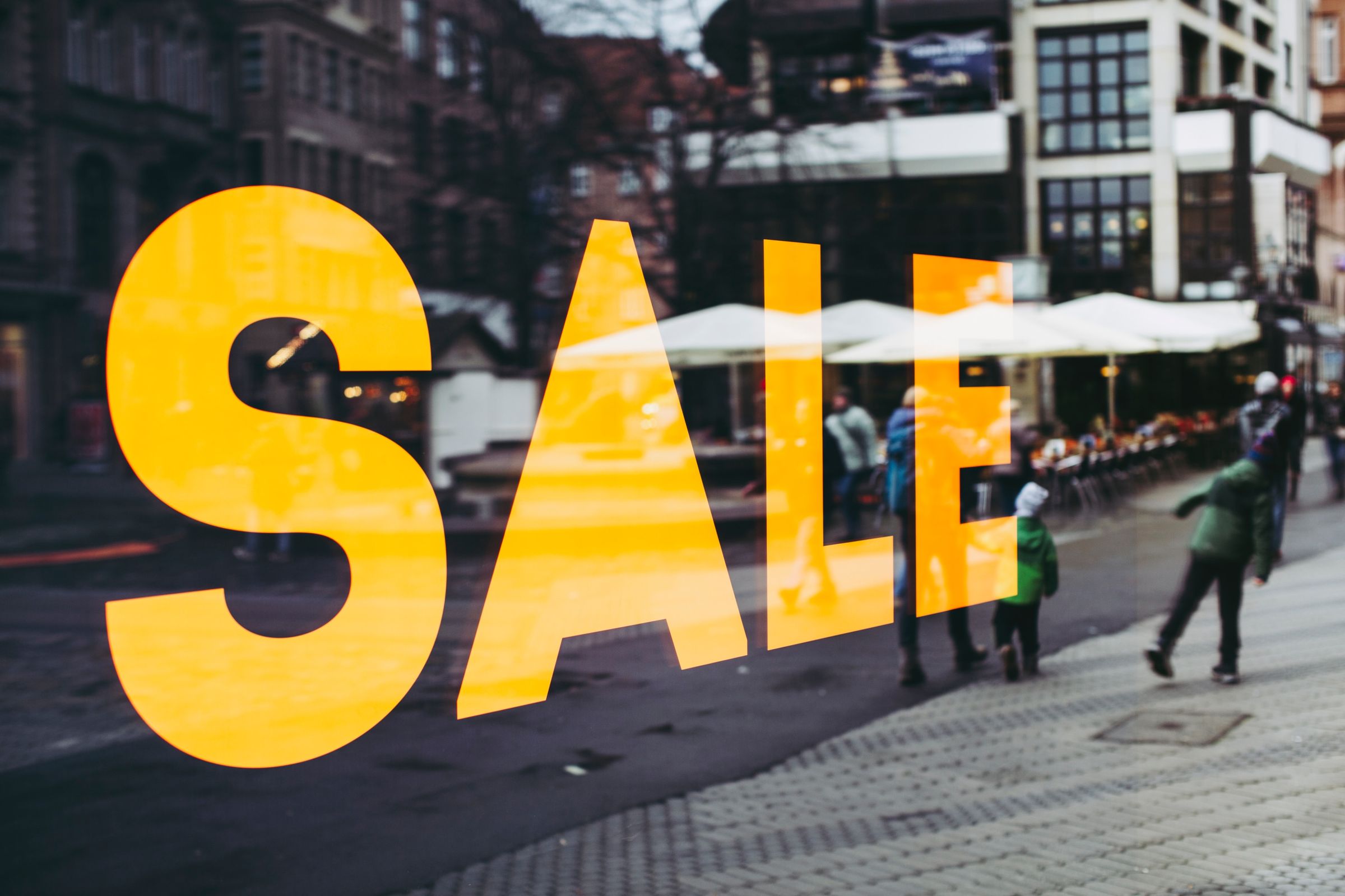 a big yellow sign sale on a store window